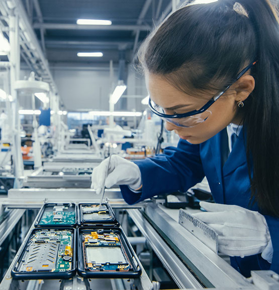 Eine Technikerin, die eine Platine in der Fertigungsanlage platziert.